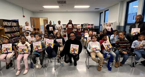 a photo of students holding Ruby Bridges' new book at a read-a-long